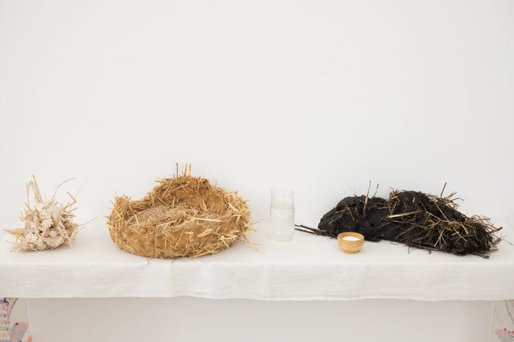 Victoria Stoian, Linişte, 2024 2026, argilla, paglia, grano, vetro, vino, tessuto, legno, 125 x 125 x 30 cm © ph Nadia Pugliese